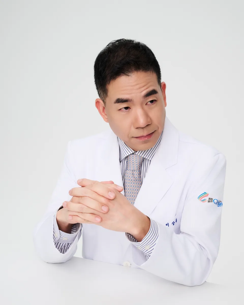 이상훈 이사장, 흰 가운을 입고 앉은 모습